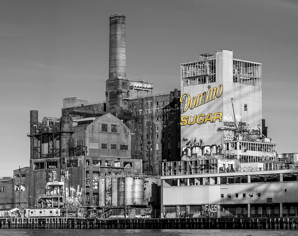 The Domino Sugar Refinery on the Williamsburg waterfront, its yellow sign lit